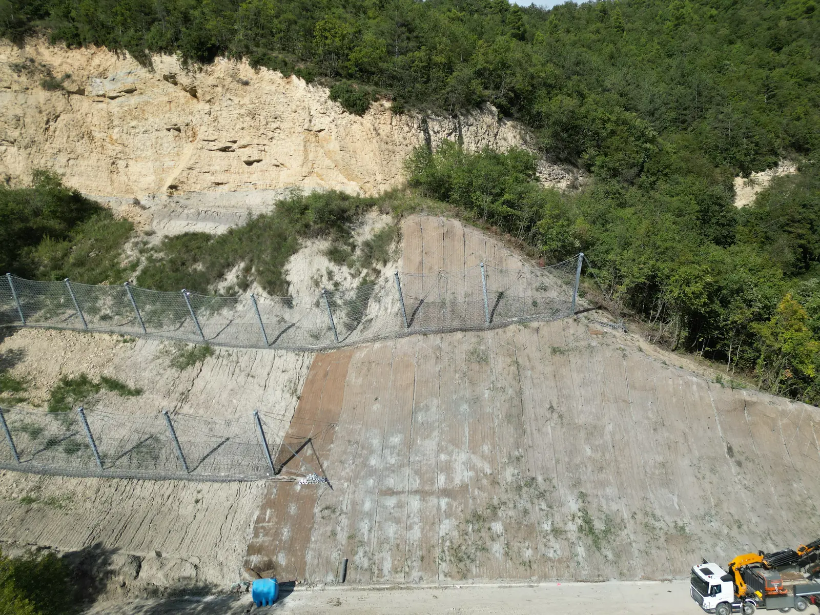 Barriere paramassi installate sotto la parete e scarpata rivestita con rete metallica in aderenza
